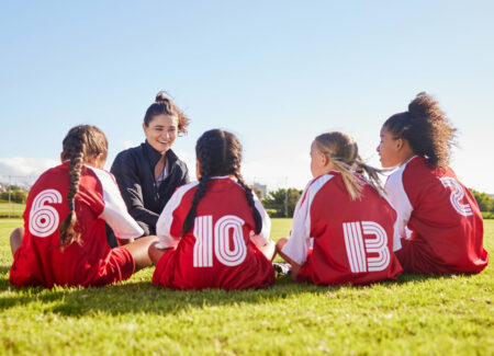 Kinder sitzen mit Trainerin